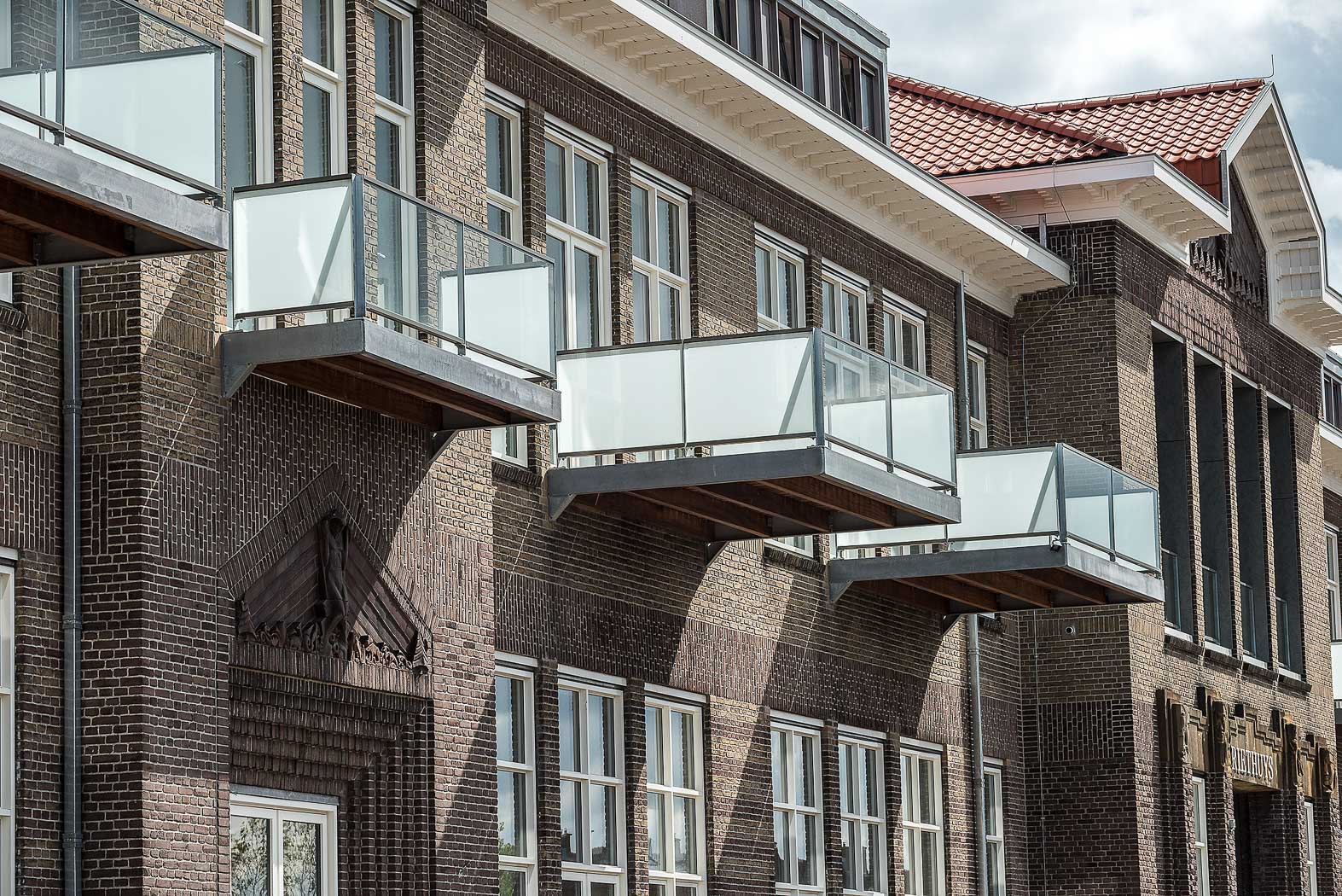 Achtergevel met nieuwgeplaatste balkons. Riethuys Almelo, voormalig schoolgebouw getransformeerd naar 34 sociale huur appartementen.