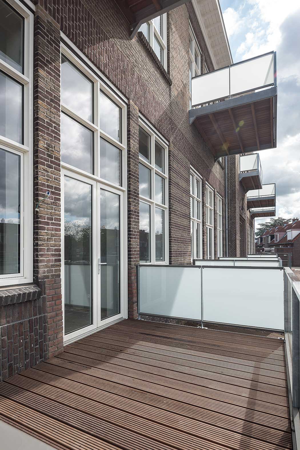 Zijgevel met balkons Riethuys Almelo, voormalig schoolgebouw getransformeerd naar 34 sociale huur appartementen.
