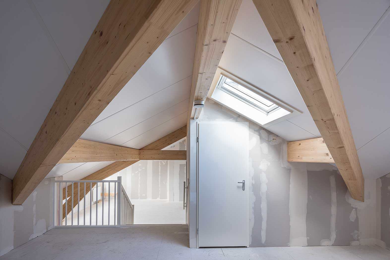 Casco ruwbouw met gebinten in zicht op topverdieping. Riethuys Almelo, voormalig schoolgebouw getransformeerd naar 34 sociale huur appartementen.
