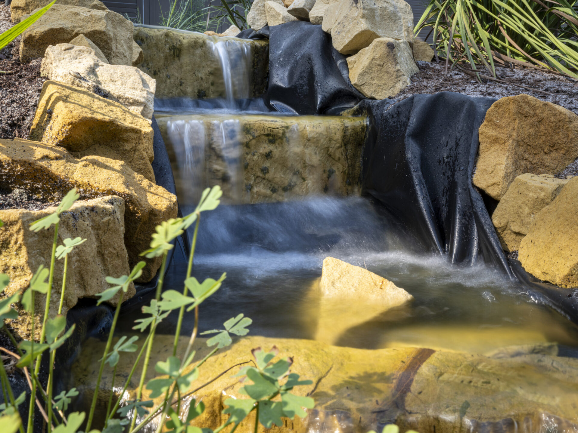Renovatie klimatenkas Hortus Botanicus Amsterdam met verduurzaming en creatieve oplossingen. Waterval met Amsterdamse stoeptegels.