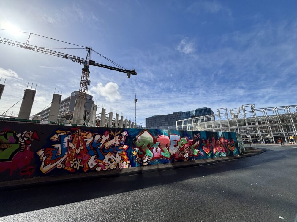 Zonnige plaat van de bouwschutting rondom bouwproject Leiden, De Geus. Voorzien van gewenste graffiti